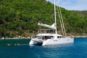 A family enjoys some leisure time in the waters behind their luxury catamaran.