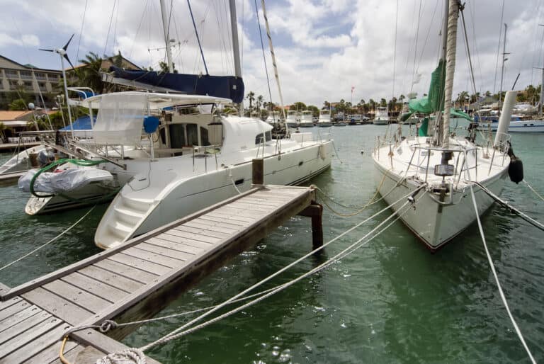 A catamaran and sailboat (monohull) are shown in dock.