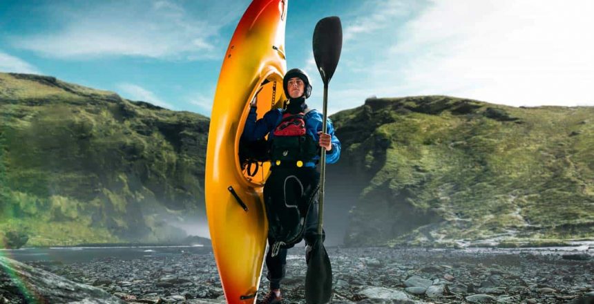 A kayaker holds up his kayak while out on expedition.