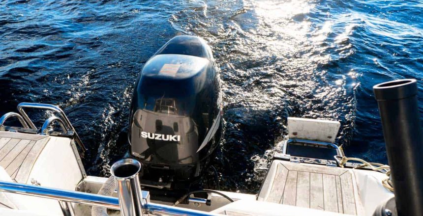 A Suzuki outboard engine is shown operating attached to the rear of a boat.